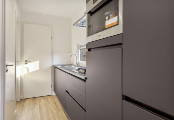 Cocina moderna en la lodge Module Special Wellness en Bospark Ede, Países Bajos, con gabinetes oscuros.