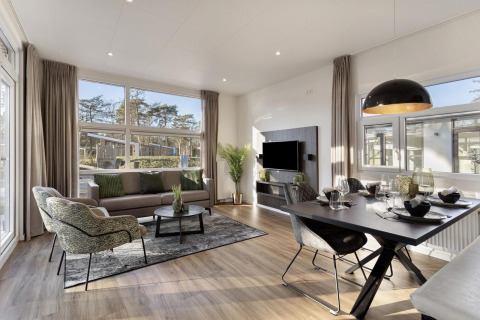Moderne lodge med store vinduer, stue og spiseområde i Bospark Ede, Nederlandene, Module Special Wellness.