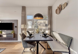 Comedor moderno con sillas y banco elegantes en el lodge Module Special Wellness de Bospark Ede, Países Bajos.