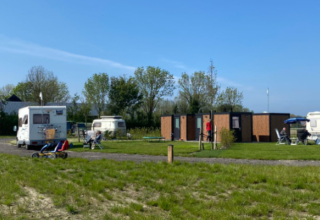 Caravans en campers op Minicamping Hofstede Zonnevliet tijdens een zonnige dag in Zeeland, Nederland.