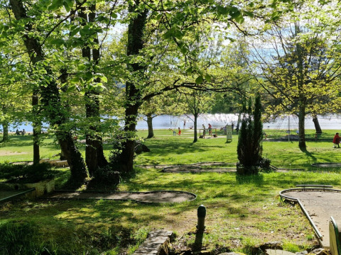 Grüner Blick über Minigolfplatz und Park am See im Camping Montard, Nouvelle-Aquitaine, Frankreich.