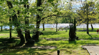 Vista verde sobre el campo de minigolf y parque junto al lago en Camping Montard, Nouvelle-Aquitaine, Francia.