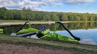 Barcas de pedales verdes con toboganes en un lago del Camping Montard en Nouvelle-Aquitaine, Francia.
