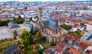Vista aérea de una catedral histórica rodeada de casas en Lamongerie, Nouvelle-Aquitaine, Francia.