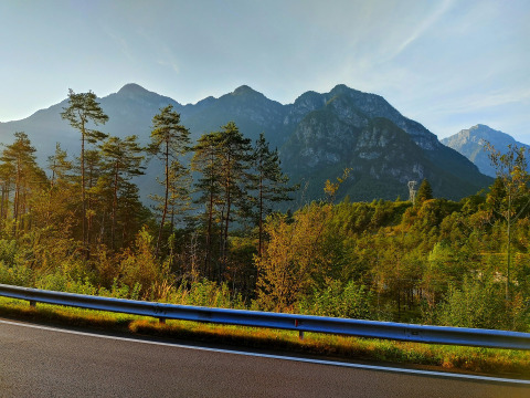Scenic view of forested mountains near Sistiana, Friuli-Venezia Giulia, Italy, seen from a road with guardrail.