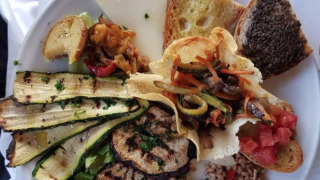 Un piatto di antipasti italiani con verdure grigliate, formaggio, pane e insalate al Camping Il Collaccio.