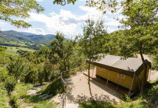 Tent set up at Camping Il Collaccio holiday park in Umbria, Italy, overlooking scenic green hills.