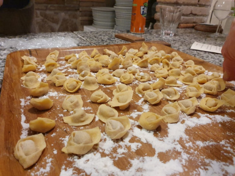 Vers gemaakte tortellini op een met meel bestrooid houten dienblad op Camping Il Collaccio in Umbrië, Italië.
