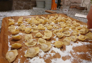 Frisklavet tortellini-pasta på et fad med mel, klar til madlavning på Camping Il Collaccio i Umbrien, Italien.