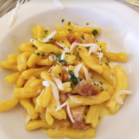 Un piatto di pasta fresca con salsa cremosa e pancetta, servito vicino a Preci in Umbria, Italia.