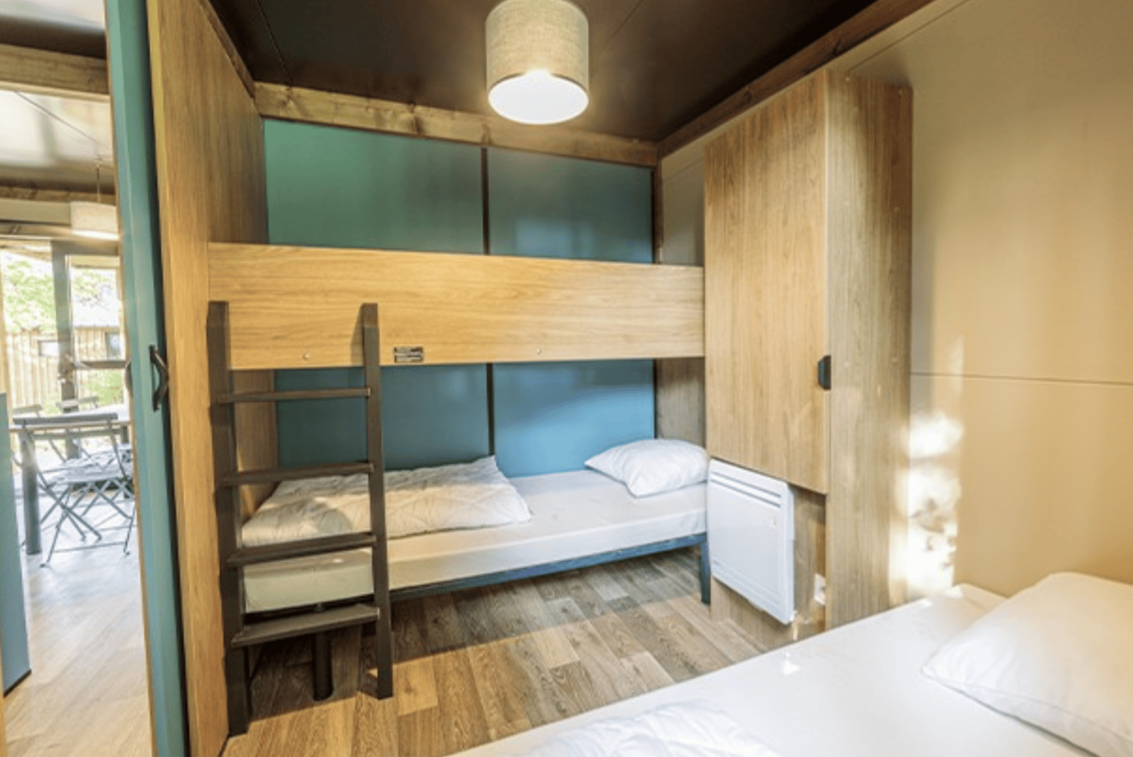 Interieur van Chalet Evasion bij Camping de Lyon in Frankrijk met stapelbedden en een modern ontwerp.