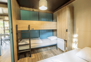Interiøret af Chalet Evasion ved Camping de Lyon i Frankrig viser køjesenge og et lyst, moderne design.