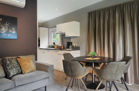 Modern living and kitchen area at Mountain Lodges, featuring elegant decor and comfortable furnishings.