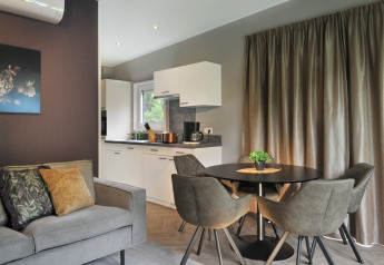 Moderne leef- en keukenruimte bij Mountain Lodges met stijlvolle inrichting en comfortabele stoelen.