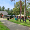 Holiday park with café, bicycles, and playground surrounded by trees at Camping Kempen, Antwerp, Belgium.