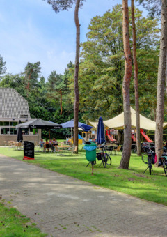 Parque vacacional con cafetería, bicicletas y zona de juegos en Camping Kempen, Amberes, Bélgica.