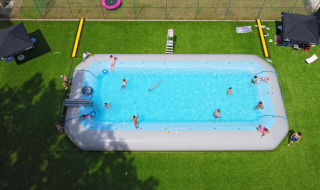 Vakantiegangers genieten van een groot opblaaszwembad bij Camping Kempen, een vakantiepark in Antwerpen, België.