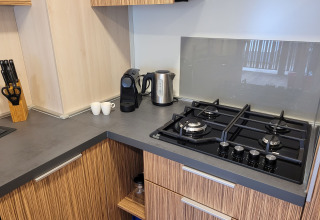 Cocina moderna en SunLodge Katsura con estufa de gas, cafetera, hervidor y bloque de cuchillos.