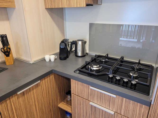 Modern kitchen at SunLodge Katsura featuring a gas stove, coffee machine, kettle, and knife block.