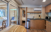 Interior of SunLodge Katsura featuring a modern kitchen, dining table, cozy bedroom, and outdoor terrace area.