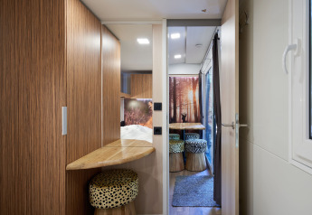 Vue intérieure de la SunLodge Katsura avec finitions bois, fenêtre et espace repas chaleureux.