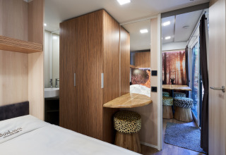 Moderne indretning i SunLodge Katsura ved hu Park Albatros Village, Italien, med træmøbler og dyreprintsskamler.