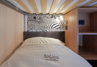 En moderne køjeseng på SunLodge Katsura i hu Park Albatros Village, Italien, med zebramønster på væggen.