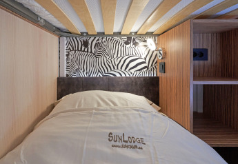 Una cama moderna en SunLodge Katsura en hu Park Albatros Village, Italia, con pared decorada de cebras.