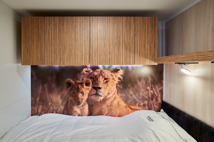 Cama con sábanas blancas y mural de leones en SunLodge Katsura, hu Park Albatros Village, Italia.