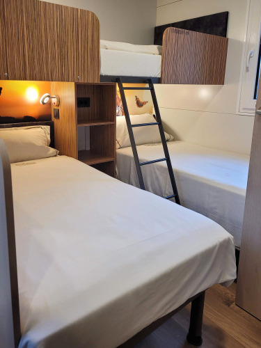 Habitación en SunLodge Katsura de hu Park Albatros Village, Italia, con camas literas y mobiliario moderno.