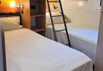 Habitación en SunLodge Katsura de hu Park Albatros Village, Italia, con camas literas y mobiliario moderno.