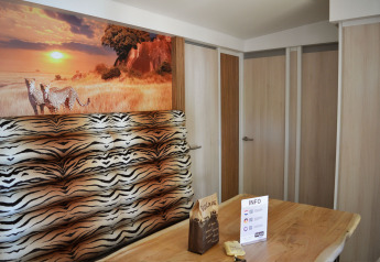 Interior de SunLodge Sabai con mural de guepardos, banco con estampado de cebra y mesa de madera.