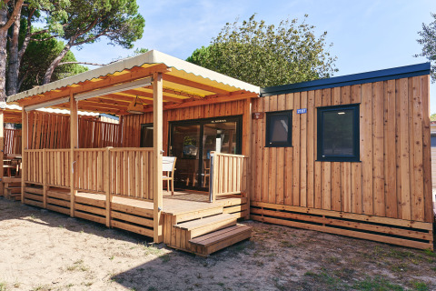 Vue ensoleillée du SunLodge Sabai en bois avec terrasse couverte, fenêtres modernes et coin détente.