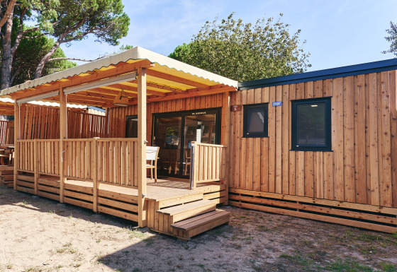 Vue ensoleillée du SunLodge Sabai en bois avec terrasse couverte, fenêtres modernes et coin détente.