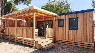 Vista soleada del SunLodge Sabai con revestimiento de madera, terraza cubierta y ventanas modernas.