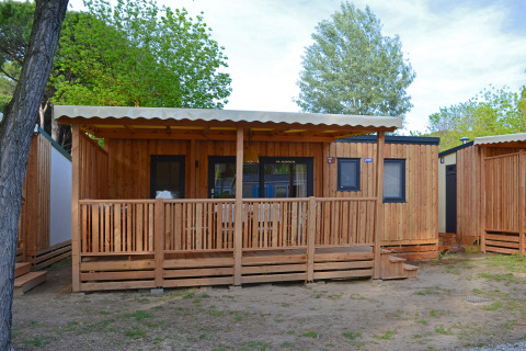 Cabaña SunLodge Sabai de madera en Camping Village Marina di Venezia rodeada de árboles, Italia.