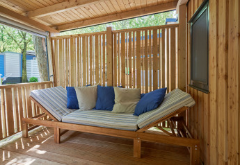 Outdoor lounge with wooden furniture and cushions at SunLodge Katsura, Camping Bella Italia, Italy.