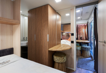 Modern interior of SunLodge Katsura at Camping Bella Italia with wood accents, cozy bed, and animal print stools.