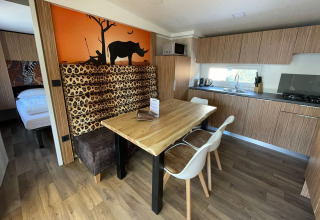 Moderne køkken og spiseområde i SunLodge Babul, dekor med dyreprint og savannemaleri i baggrunden.