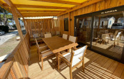 Terraza soleada de madera con muebles en SunLodge Babul, Camping Village Marina di Venezia, Italia.