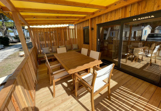 Terraza soleada de madera con muebles en SunLodge Babul, Camping Village Marina di Venezia, Italia.