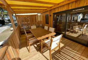 Zonnig houten terras met tuinmeubilair bij SunLodge Babul, Camping Village Marina di Venezia, Italië.