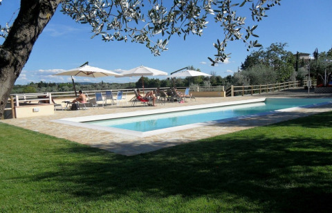 Außenpool mit Liegestühlen, Sonnenschirmen und gepflegtem Rasen im Agricamping Romita, Toskana, Italien.
