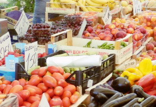 Donna che vende frutta e verdura fresca al mercato locale di Agricamping Romita, in Toscana, Italia.