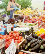 Donna che vende frutta e verdura fresca al mercato locale di Agricamping Romita, in Toscana, Italia.
