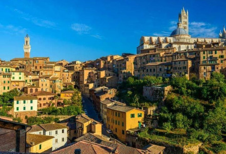 Veduta di edifici storici e del duomo vicino a Tavarnelle Val di Pesa, Toscana, con cielo limpido.