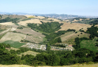 Panoramic view of rolling hills, fields, and wooded valleys near Monteciccardo, Marche, Italy.