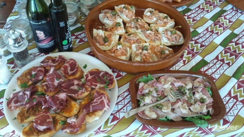 Entrantes italianos con embutidos y pan sobre una mesa en Camping Podere sei Poorte, Marche, Italia.