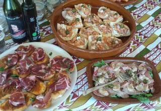 Italienske forretter med pålæg og brød på et bord ved Camping Podere sei Poorte, Marche, Italien.