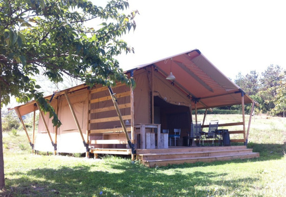 Tienda safari con instalaciones sanitarias en Camping Podere Sei Poorte en Italia, terraza y sillas visibles.